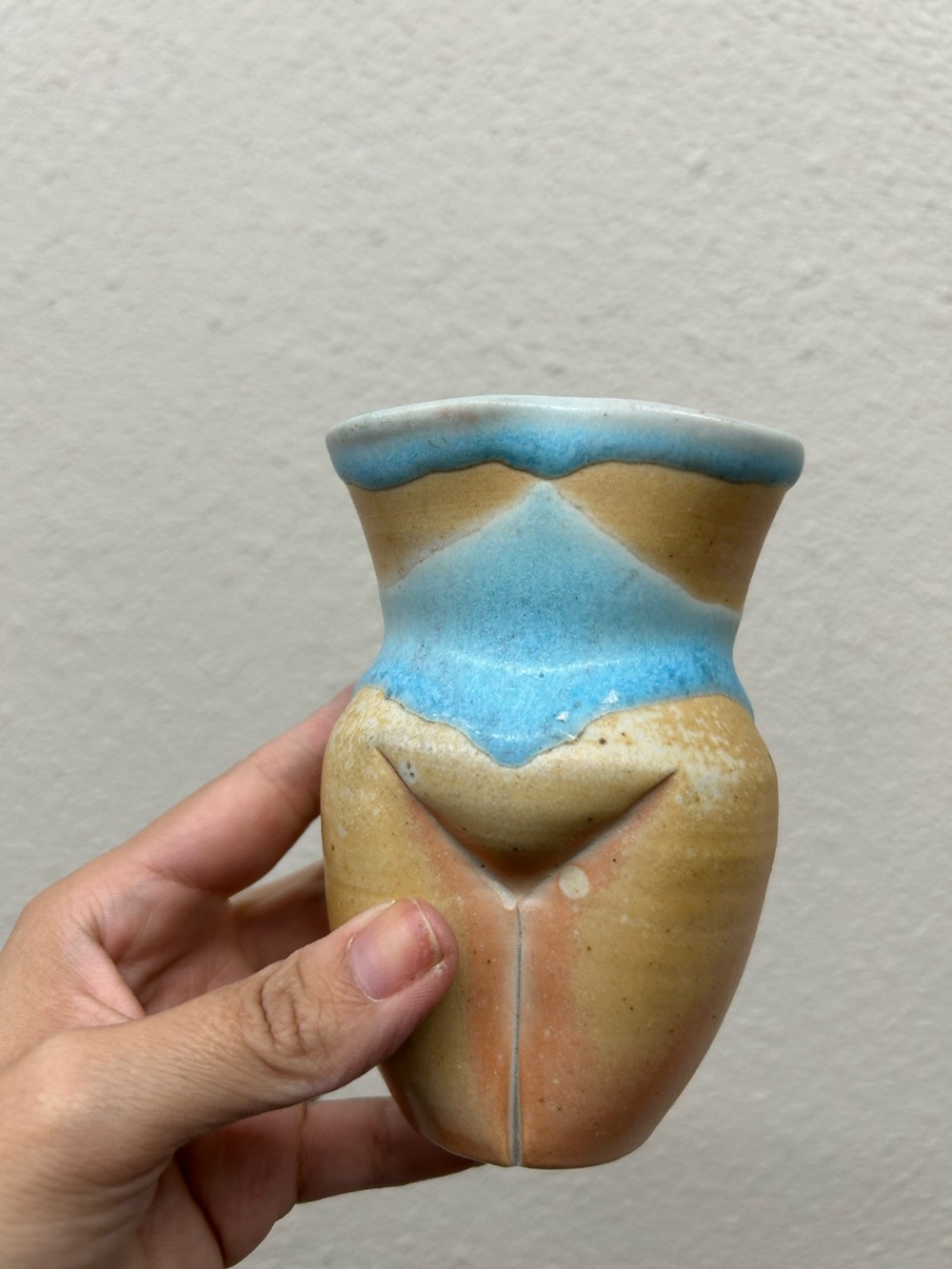 small, handmade ceramic body-form vase featuring earth-tone speckled clay